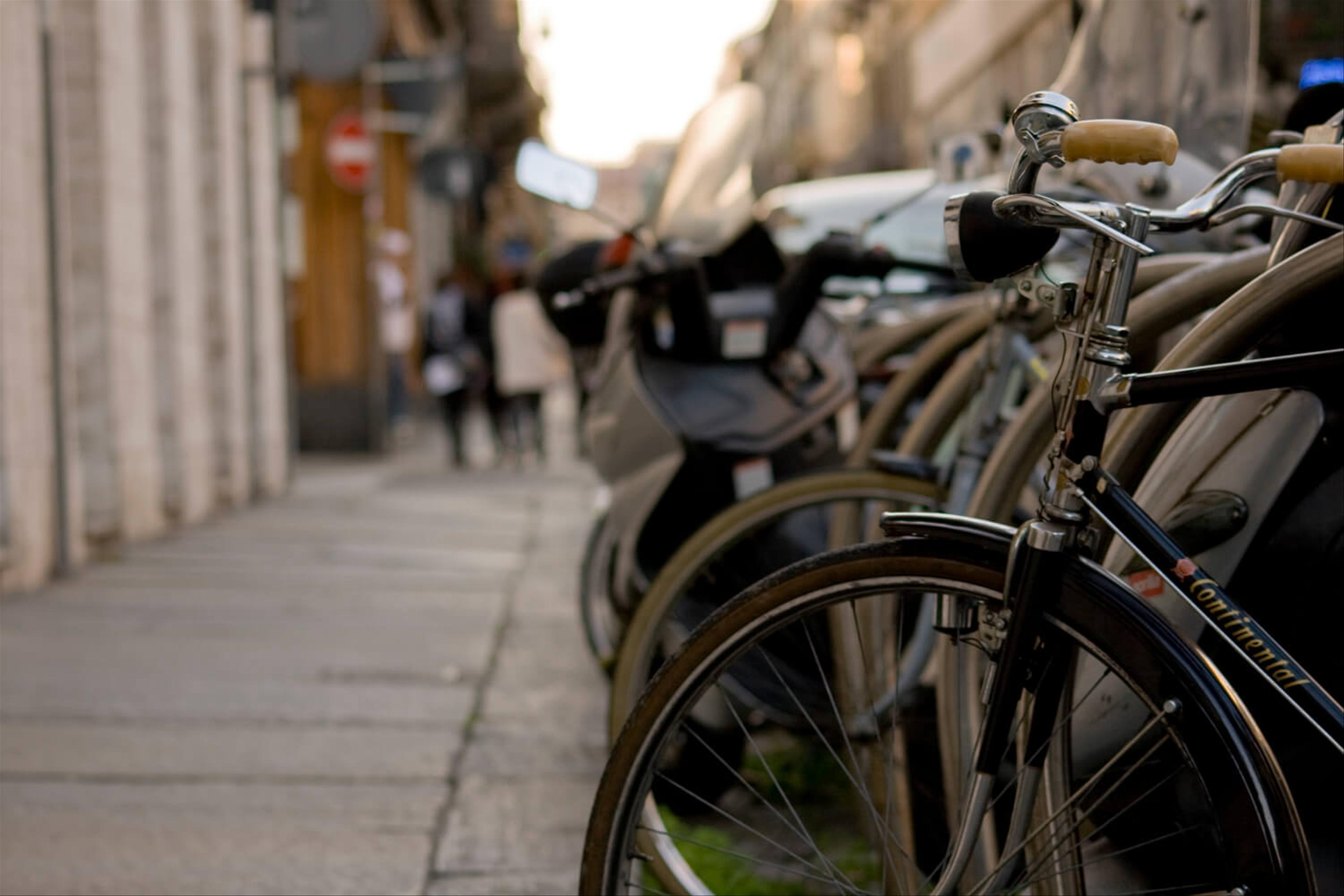 A row of bicycles in a rack alongside a path in a city