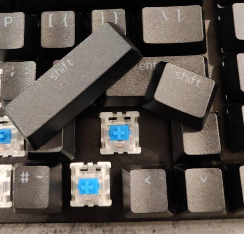 Several different sized shift keycaps next to a space on a keyboard that is not the same size as either